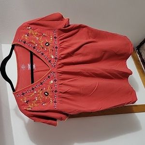 Dark orange tee with blue and yellow embroidered flowers